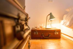een tafel met een lamp en twee glazen op een koffer bij Room En Suite la Corte Assisi in Assisi