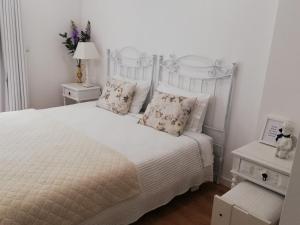 a white bedroom with a white bed with pillows at Red House By The River in Porto