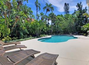 a swimming pool with two deck chairs and a swimming poolvisorvisor at Shell Beach Home 209 in Sarasota