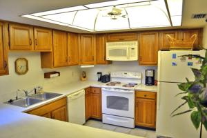 uma cozinha com um frigorífico branco e um lavatório em Midnight Cove 6327 #725 em Sarasota