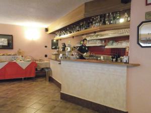 een man achter een bar in een restaurant bij Hotel Adele in Livigno