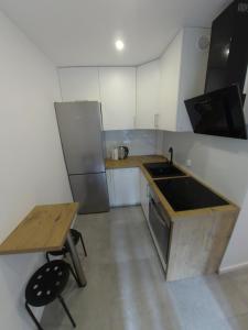 Il comprend une petite cuisine avec un évier et une table en bois. dans l'établissement Sea & Sand Apartment, à Gdańsk