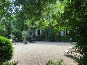 una casa con mesas y sillas en un patio en Les Chambres d'Hôtes du Bois Joli en Semur-en-Auxois