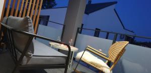 - Balcón con 2 sillas y mesa en Genius Guest Unique Banovci Apartment en Banovci