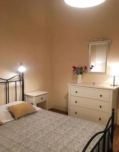 a bedroom with a bed with a dresser and a mirror at La Casa del Geco in Avola