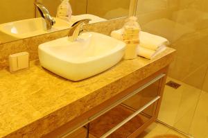 Apto Novo e Moderno no Centro de Gramado في غرامادو: طاولة حمام مع حوض ومرآة +22 صورة