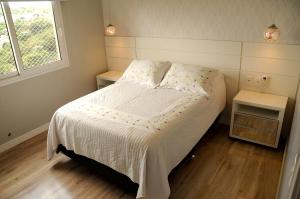 Apto Novo e Moderno no Centro de Gramado في غرامادو: غرفة نوم صغيرة بها سرير ونافذة