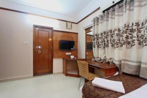 a hotel room with a desk and a window at Bluemoon Grand in Bangalore