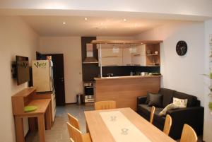 a living room with a couch and a table and a kitchen at Penzion Na Dědině in Mutěnice