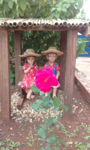 two little girls in hats sitting on a bench at Vila Formosa Rural in São Pedro