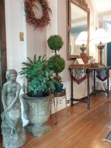 a vase with plants in a room with a mirror at Hanover House Bed and Breakfast in Niagara Falls