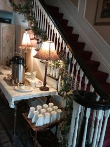a staircase with a table with cups and a lamp at Hanover House Bed and Breakfast in Niagara Falls
