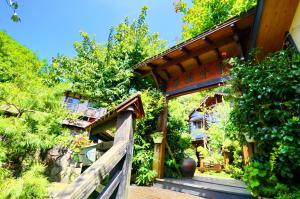 a house with a wooden porch and a wooden fence at Shiyai Taoyuan in Ren'ai