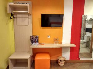 JombangGreen Red Hotel Syariah Jombang的腿部间 - 带书桌和床