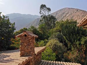 a stone chimney on a roof with mountains in the background at Villa Celestial in Nieve Nieve