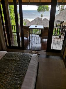 a room with a bed and a view of the ocean at Beyond The Blue Horizon Boutique Bungalows in Haad Chao Phao