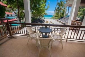 uma mesa e cadeiras numa varanda com vista para a praia em Sur Beach Resort Boracay em Boracay