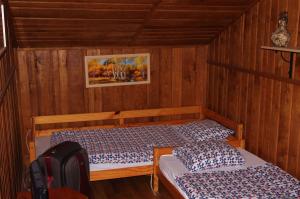 a room with two beds in a wooden room at Tölgyfakuckó apartman in Baja