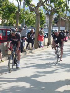 two men riding bikes down a city street at Pension Casa Austria in Calella