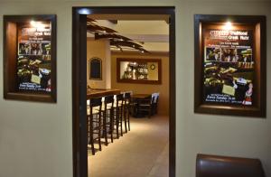 a dining room with a bar with chairs and posters on the wall at 24 Seven Boutique Hotel in Malia