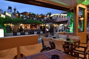 a restaurant with a table and chairs and a bar at 24 Seven Boutique Hotel in Malia