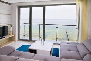 ウストロニエ・モルスキエにあるApartamenty Na Klifieのリビングルーム(ソファ付)が備わり、海の景色を望めます。