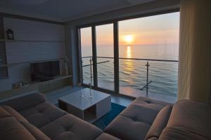 salon z kanapą i widokiem na ocean w obiekcie Apartamenty Na Klifie w mieście Ustronie Morskie
