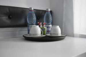 two bottles and two cups on a table at Cazare Moldi Btt in Câmpulung Moldovenesc