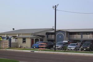 a row of houses with cars parked in a parking lot at Americas Best Value Inn Port Aransas in Port Aransas