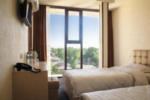 a hotel room with a bed and a large window at Friday in Tashkent