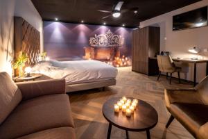een slaapkamer met een bed, een bank en een tafel bij Fletcher Hotel-Restaurant de Korenbeurs in Made