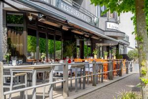 une rangée de tables et de chaises devant un bâtiment dans l'établissement Fletcher Hotel-Restaurant de Korenbeurs, à Made