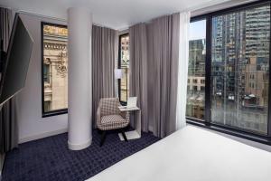 a hotel room with a desk and a large window at Hyatt Centric Faneuil Hall Boston in Boston