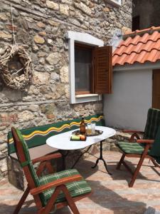 a patio with a table and chairs and a building at Chora Samothrakis, House with courtyard in Samothráki