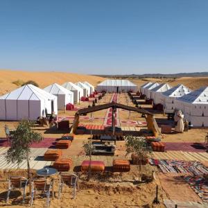 a group of tents and chairs in the desert at Ammar Luxury Camp in Merzouga