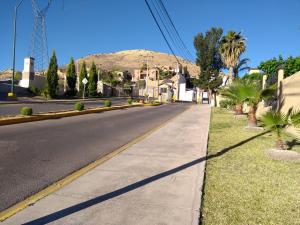 una calle vacía con una montaña en el fondo en Hermoso Depto por UACH II Con Terraza y linda vista, en Chihuahua