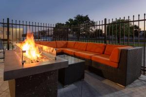 a couch sitting next to a fire pit at La Quinta by Wyndham Wichita Airport in Wichita