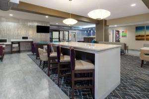 a lobby with a bar with chairs and a tv at La Quinta by Wyndham Wichita Airport in Wichita