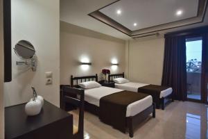 a hotel room with two beds and a mirror at 24 Seven Boutique Hotel in Malia