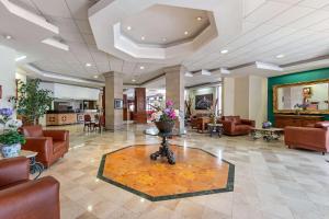 um átrio com cadeiras e uma mesa com flores em Hotel Quality Inn Aguascalientes em Aguascalientes