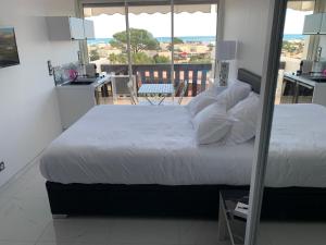 um quarto com uma cama grande e uma varanda em VILLAGE NATURISTE em Cap d'Agde