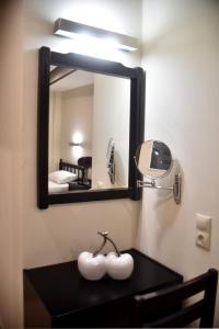 a bathroom with a mirror and a table with a sink at 24 Seven Boutique Hotel in Malia