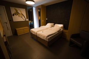 Un pequeño dormitorio con una cama y una silla. en Su'ro Bed and Breakfast, en Gante