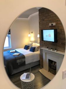 a bedroom with a bed and a tv above a fireplace at The Bold St LiverPods by Serviced Living Liverpool in Liverpool