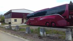 a red double decker bus parked in front of a building at Le Magiot in Montliot-et-Courcelles