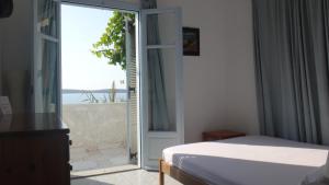 a bedroom with a bed and a sliding glass door at Blue & Sea Studios Apartments in Drios