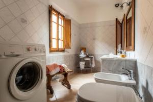 a bathroom with a washing machine and a sink at A casa di Irma e Nilo in Palaia