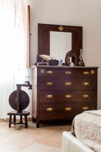 a bedroom with a dresser with a mirror and a chair at A casa di Irma e Nilo in Palaia