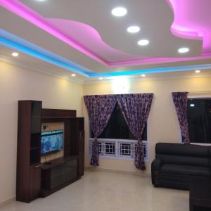 a living room with purple lights on the ceiling at Adhithya Holidays in Kodaikānāl