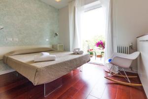 a bedroom with a bed and a chair and a window at Relais Star of Trastevere in Rome